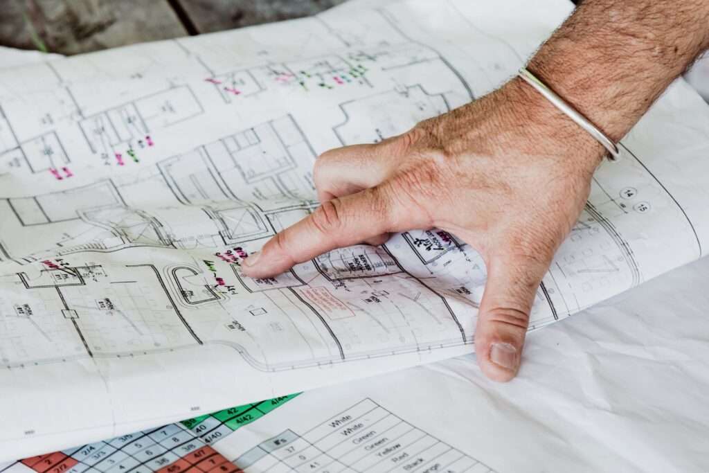 Pointing out the details of the plan with a finger. 