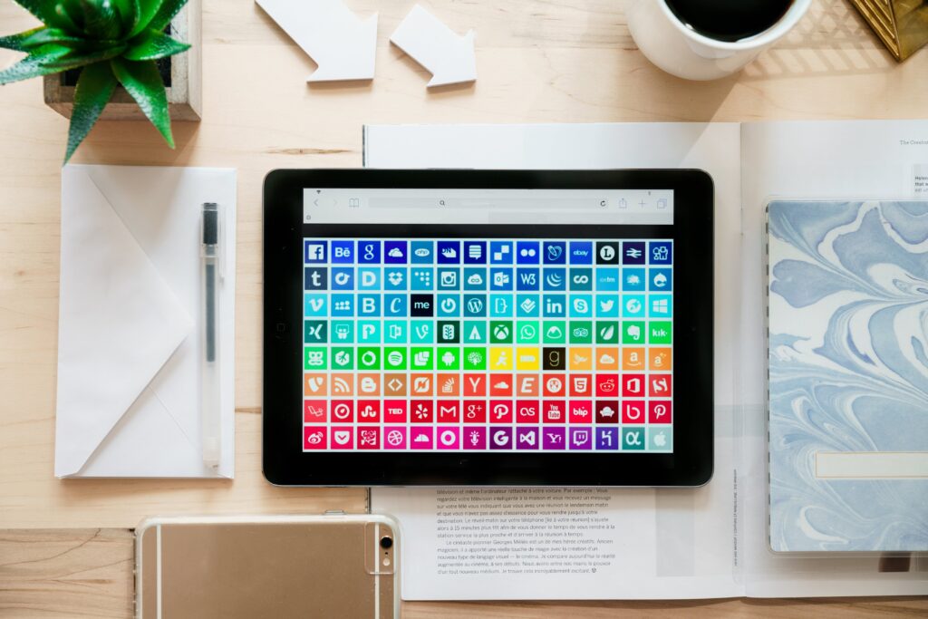 ipad with colorful array of social media apps in color coordinated order. 